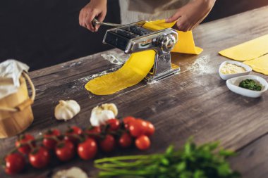 Ev yapımı makarnayı ahşap masada makarna makinesiyle hazırlıyorum..
