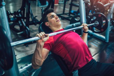 Spor salonunda egzersiz yapan yakışıklı bir genç.