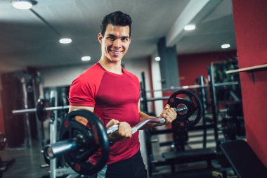 Spor salonunda egzersiz yapan yakışıklı bir genç.