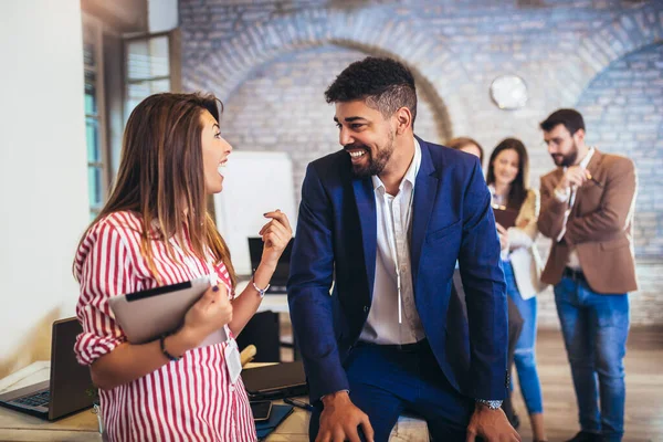 Modern ofiste yeni bir proje üzerinde çalışan iki tasarımcı.