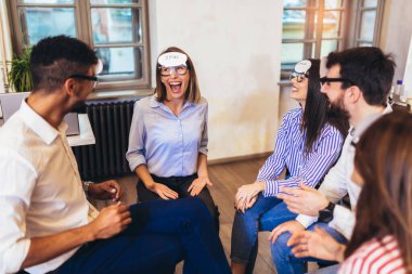 Mutlu arkadaş canlısı iş ekibi şirket eğitiminde eğleniyor, komik takım kurma aktiviteleri, tahmin et kim oynuyor..