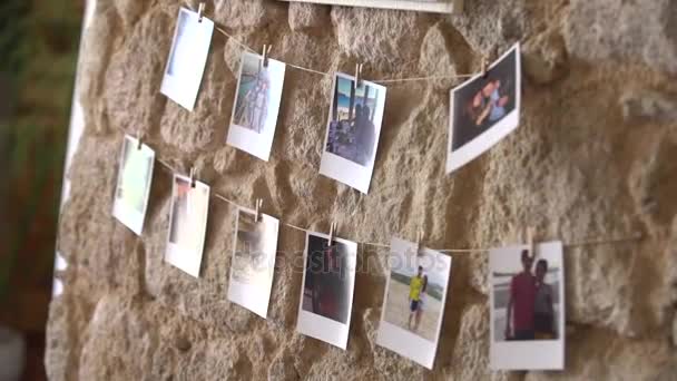 Fotos colgando de una pared de piedra — Vídeo de stock