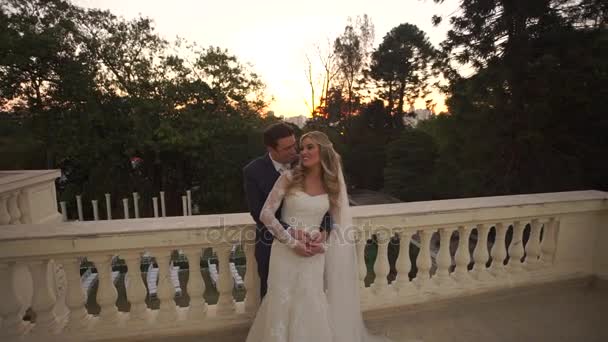 Bruden och brudgummen kramas på balkong — Stockvideo
