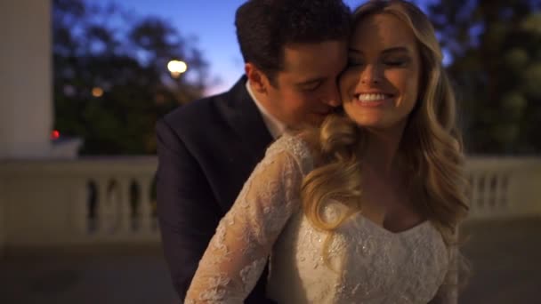 Braut und Bräutigam umarmen sich auf einem Balkon — Stockvideo