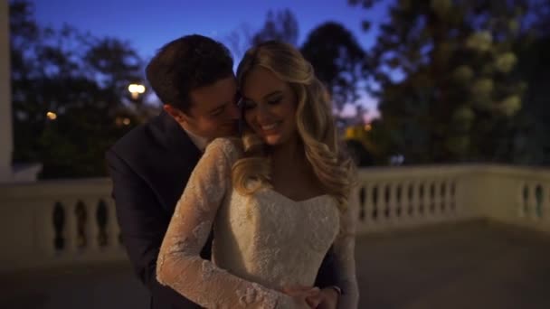 Braut und Bräutigam umarmen sich auf einem Balkon — Stockvideo