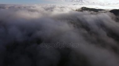 Yüksek dağların güzel bulutların üzerinden uçan