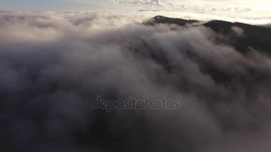 Yüksek dağların güzel bulutların üzerinden uçan