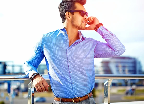 Fashion portrait of young sexy businessman handsome model man in casual cloth suit in sunglasses in the street speaking on his phone — Stock Photo, Image