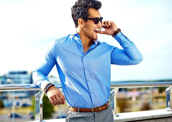 Retrato de moda de hombre de negocios sexy joven modelo guapo en traje de tela casual en gafas de sol en la calle hablando en su teléfono — Foto de Stock