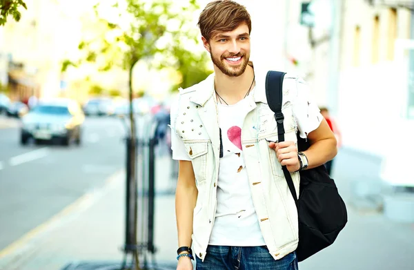 Zabawny uśmiechnięty mężczyzna przystojny hipster w lato stylowe ubrania pozowanie na ulicy tle — Zdjęcie stockowe