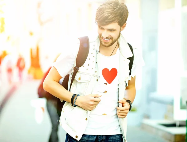 Gracioso sonriente hipster guapo hombre en elegante verano ropa posando en la calle fondo —  Fotos de Stock