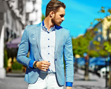 Yüksek moda bakmak. Takım elbise li genç şık, mutlu yakışıklı işadamı modeli güneş gözlüğü ile sokakta yürüyor