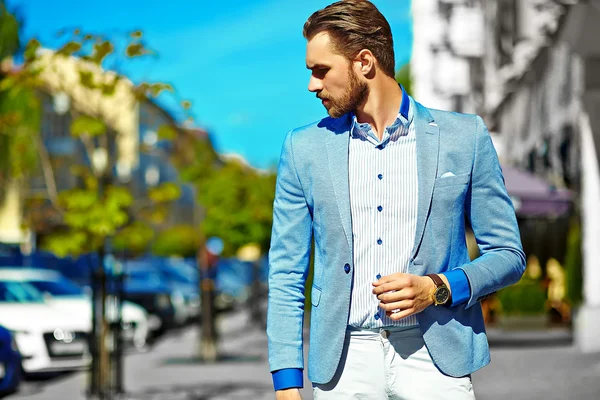 Haute couture look.Young élégant confiant heureux beau modèle d'homme d'affaires en costume vêtements marchant dans la rue en lunettes de soleil — Photo