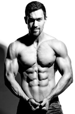 Güçlü sağlıklı yakışıklı atletik erkek Fitness Model beyaz duvara yakın poz portresi