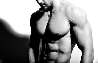 Güçlü sağlıklı yakışıklı atletik erkek Fitness Model beyaz duvara yakın poz portresi