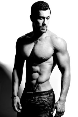 Güçlü sağlıklı yakışıklı atletik erkek Fitness Model beyaz duvara yakın poz portresi