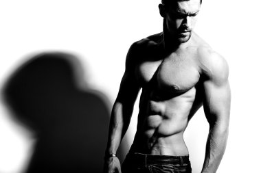 Güçlü sağlıklı yakışıklı atletik erkek Fitness Model beyaz duvara yakın poz portresi