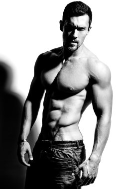 Güçlü sağlıklı yakışıklı atletik erkek Fitness Model beyaz duvara yakın poz portresi