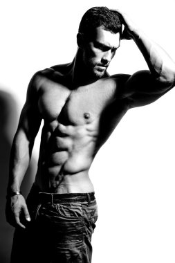 Güçlü sağlıklı yakışıklı atletik erkek Fitness Model beyaz duvara yakın poz portresi