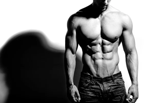 Portret van sterke gezonde knappe atletische Man Fitness Model poseren in de buurt van witte muur — Stockfoto