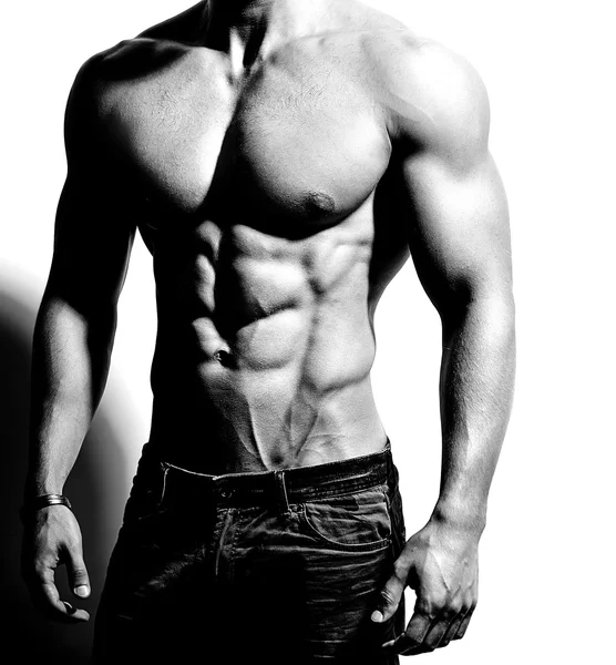 Ritratto di forte sano bello atletico uomo fitness modello in posa vicino alla parete bianca — Foto Stock