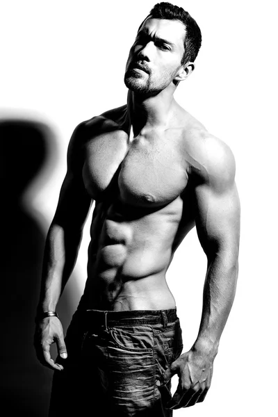 Portret van sterke gezonde knappe atletische Man Fitness Model poseren in de buurt van witte muur — Stockfoto