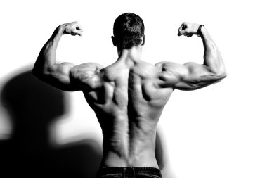 Güçlü sağlıklı yakışıklı atletik erkek Fitness Model beyaz duvara yakın poz portresi