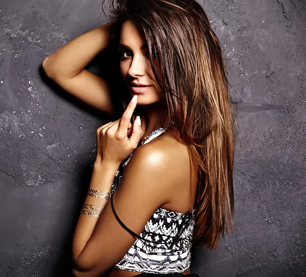 Beau modèle de fille bronzée en vêtements d'été avec un maquillage créatif lumineux posant près du mur gris — Photo