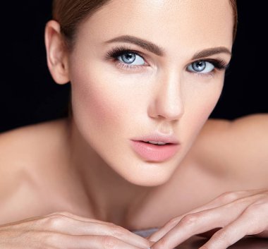 güzel bir kadın modeli hiçbir makyaj ve temiz sağlıklı cilt yüz siyah arka plan üzerine