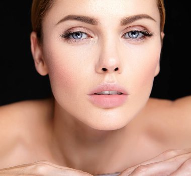 güzel bir kadın modeli hiçbir makyaj ve temiz sağlıklı cilt yüz siyah arka plan üzerine