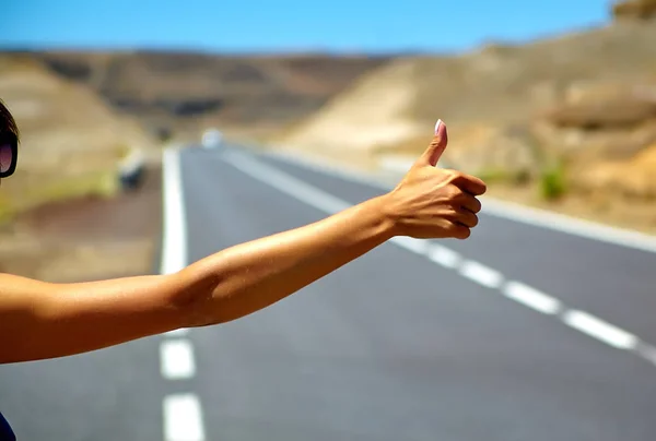 Jóvenes turistas caucásicos haciendo autostop a lo largo de un camino al atardecer —  Fotos de Stock