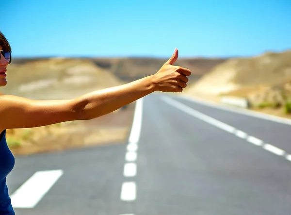 Young caucasian tourist hitchhiking along a road in sunset — Stock Photo, Image