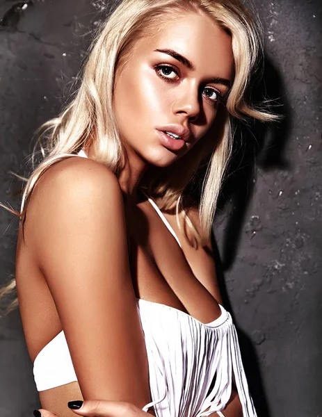 Blondes Model in sommerweißer Kleidung posiert nahe grauer Wand — Stockfoto