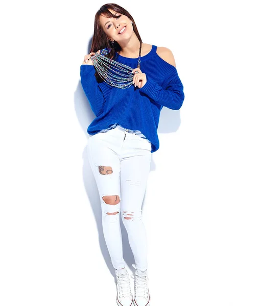 Beautiful smiling hipster brunette woman model pulling stylish summer blue sweater isolated on white background — Stock Photo, Image