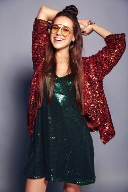 Yaz şık ceket ve yeşil elbise gri arka plan üzerinde poz yansıtan parlak parlak beyaz gülümseyen hipster esmer kadın güzel modelinde