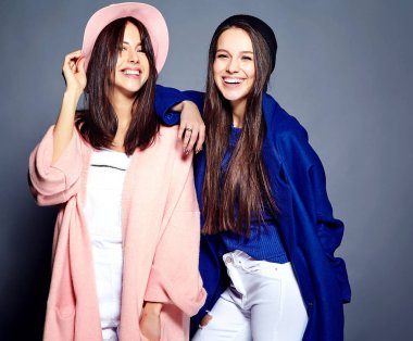 iki esmer bayan modelleri yaz casual hipster palto gri arka plan üzerinde poz içinde gülümseyen moda portre