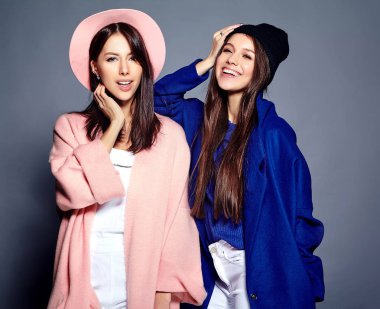iki esmer bayan modelleri yaz casual hipster palto gri arka plan üzerinde poz içinde gülümseyen moda portre
