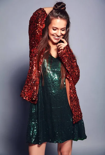 Belle caucasien souriant hipster brunette femme modèle en brillant brillant reflétant veste élégante d'été et robe verte posant sur fond gris — Photo