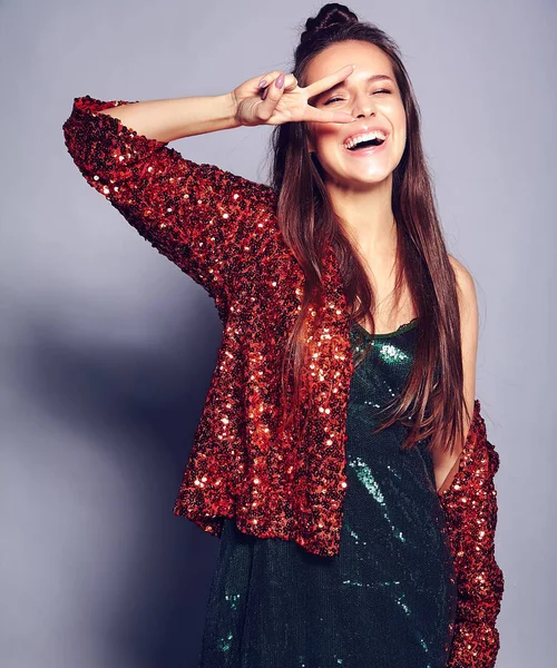 Hermosa mujer morena hipster sonriente caucásica modelo en brillante brillante reflejo chaqueta de verano elegante y vestido verde posando sobre fondo gris — Foto de Stock