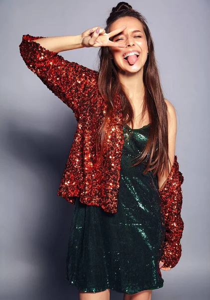 Hermosa mujer morena hipster sonriente caucásica modelo en brillante brillante reflejo chaqueta de verano elegante y vestido verde posando sobre fondo gris — Foto de Stock