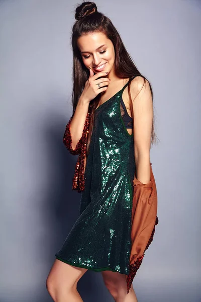 Hermosa mujer morena hipster sonriente caucásica modelo en brillante brillante reflejo chaqueta de verano elegante y vestido verde posando sobre fondo gris — Foto de Stock
