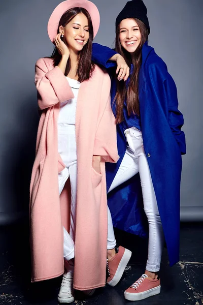Retrato de moda de dois sorridentes morena mulheres modelos no verão casual casaco hipster posando no fundo cinza — Fotografia de Stock