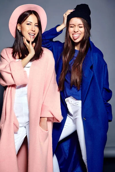 Модный портрет двух улыбающихся брюнеток женщин модели летом случайный хипстер пальто позируя на сером фоне — стоковое фото