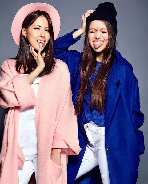 Portrait de mode de deux femmes brunes souriantes modèles en été manteau hipster décontracté posant sur fond gris — Photo