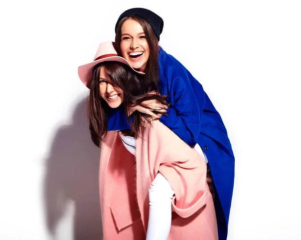 Portrait de mode de deux femmes brunes souriantes modèles en été manteau décontracté hipster isolé sur blanc. Les filles se tenant sur le dos — Photo