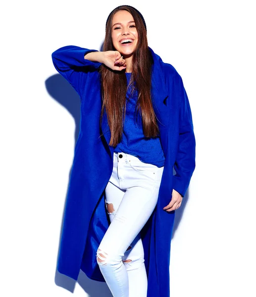 Улыбающаяся хипстерская брюнетка-модель в стильном синем пальто, изолированном на белом — стоковое фото