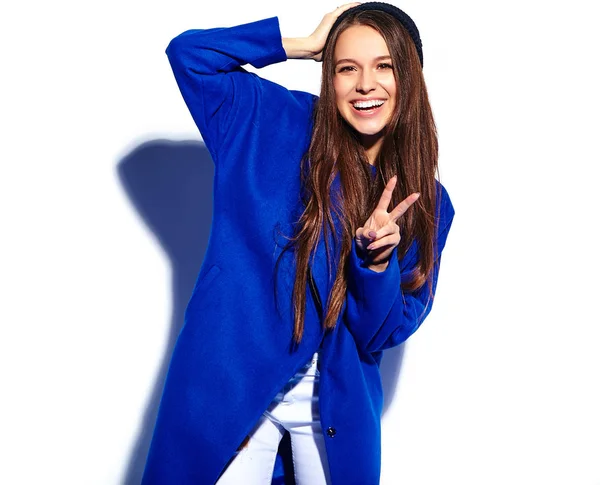 Bonito modelo de mulher morena hipster sorridente em casaco azul elegante isolado no branco — Fotografia de Stock