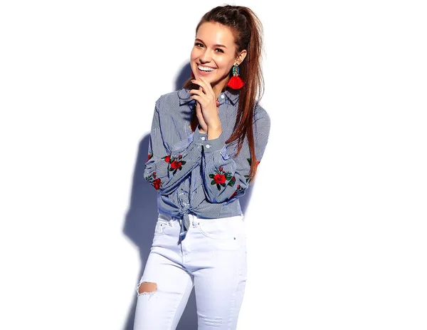 Portrait de belle femme brune hipster souriante modèle dans des vêtements bleus élégants décontractés isolés sur blanc — Photo