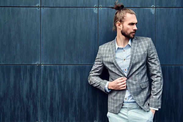 Portret van sexy knappe mode mannelijk model man gekleed in elegante geruite pak poseren buiten op de straat achtergrond — Stockfoto
