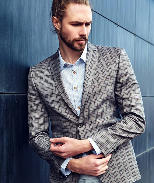 Ritratto di sexy bello moda maschio modello uomo vestito in elegante abito a scacchi posa all'aperto sullo sfondo della strada — Foto Stock